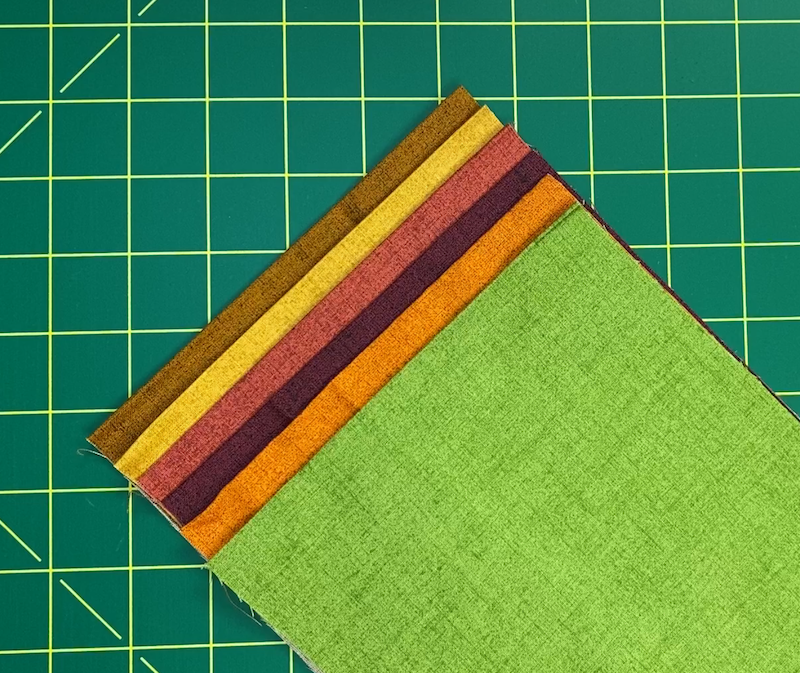 Six wide strips of fabric waiting to be cut into squares.